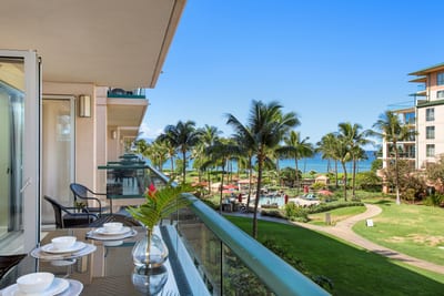 Tropical balcony bliss with ocean views and lush paradise below.