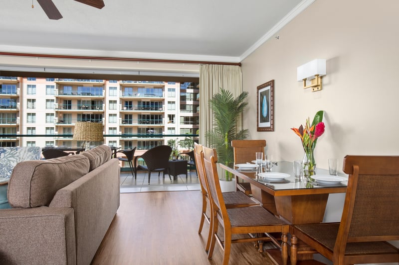Chic dining space with tropical decor and private balcony access nearby.