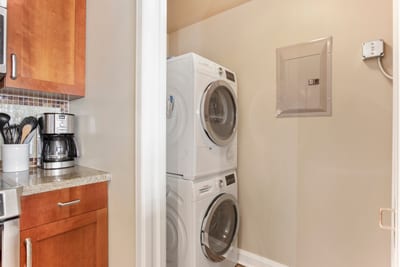 Convenient in-unit washer and dryer beside fully equipped kitchen area.