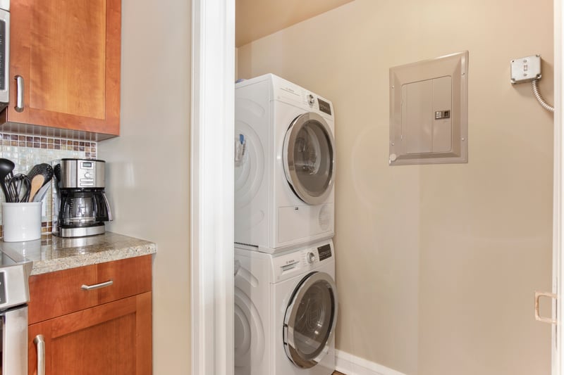 Convenient in-unit washer and dryer beside fully equipped kitchen area.