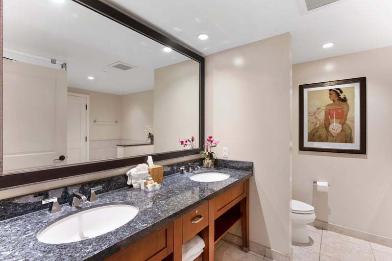 Elegant bathroom with double sinks, floral decor, and serene artwork.