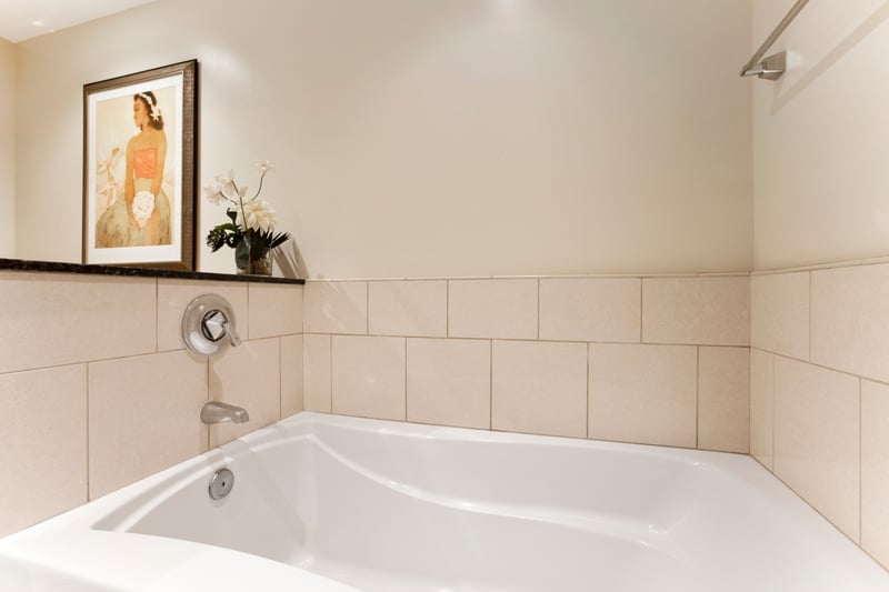 Serene soaking tub with floral accents and calming island-inspired art.