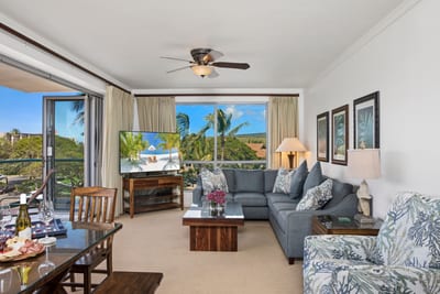 Bright and breezy living room with island-inspired decor, plush seating, and picturesque tropical landscape views