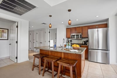 Modern island kitchen with granite counters and warm wood touches and functionality for everything you'll need