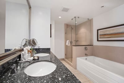 Modern bathroom with granite vanity, glass shower, and soaking tub