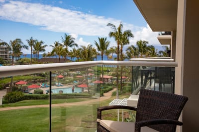 Balcony serenity with ocean views, palm trees, and poolside bliss.