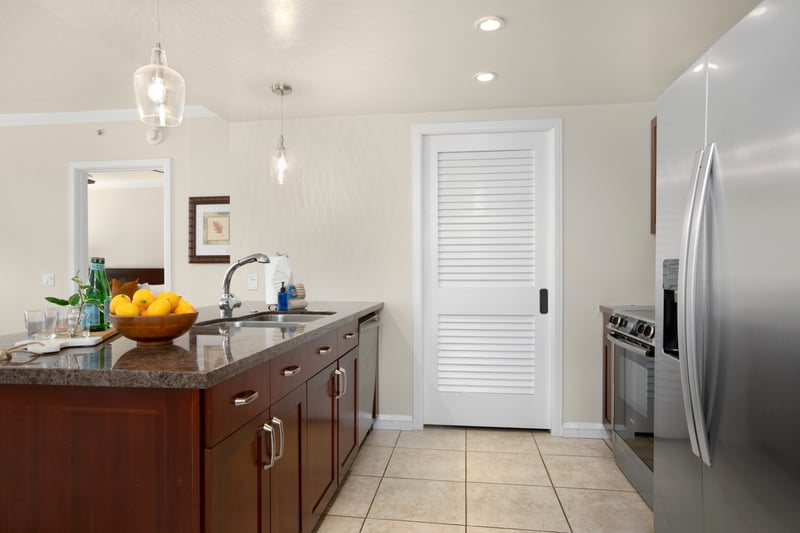 Well-equipped kitchen with sleek counters, pendant lighting, and tropical flair.