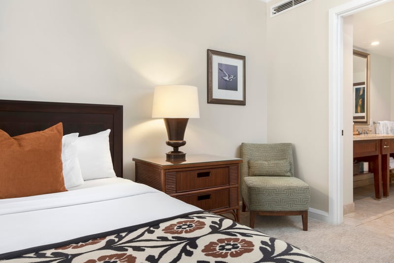 Chic island bedroom corner with plush seating, soft lighting, ensuite luxury.