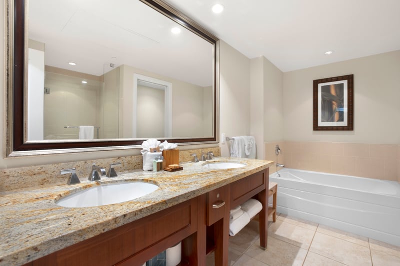 Luxurious bathroom with double sinks, granite countertops, and soaking tub.