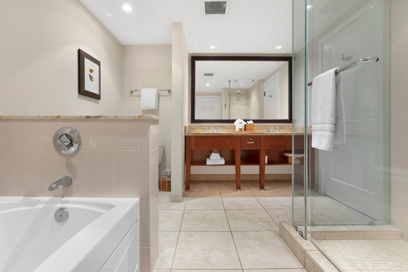 Spacious bathroom with soaking tub, glass shower, and double vanity luxury.