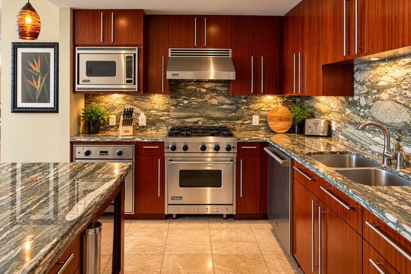 Wood cabinetry, a stone backsplash, a range with oven and a double sink give the cook plenty of room to prepare meals.