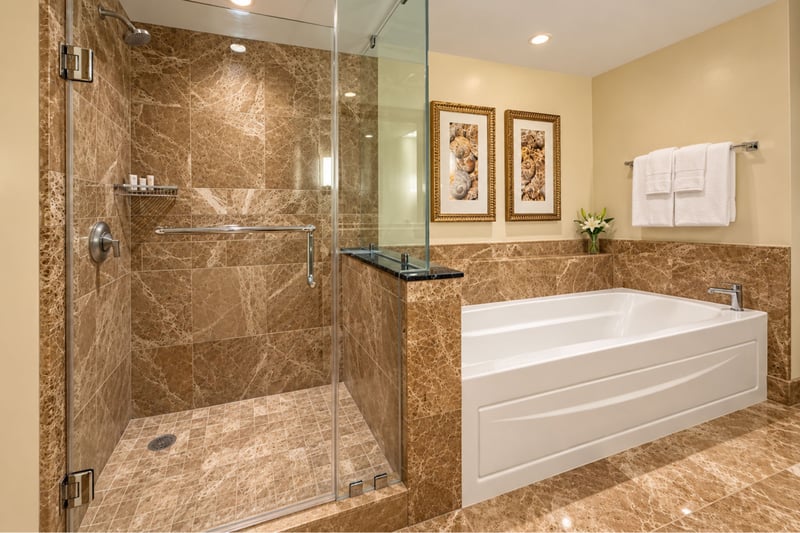 A glass enclosed shower and a separate bathtub share this bathroom, framed by seashell artwork and fresh white towels.