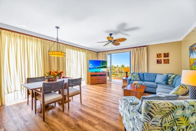 Gather in the bright, open-concept living area with plush seating, Smart TV, and direct balcony access.