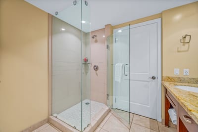 The walk-in shower and granite vanity offer simple comfort in the guest bathroom.