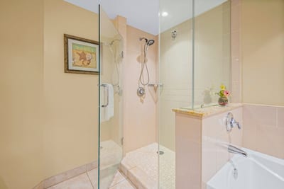 A glass walk-in shower and warm tile details add ease and elegance to your ensuite bath.