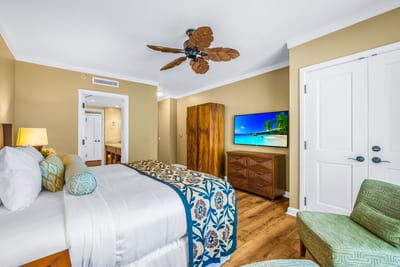 This guest room offers a Queen bed, ceiling fan, and Smart TV in a cheerful, island-inspired setting.