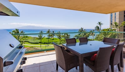 Covered balcony with dining table and panoramic ocean views, perfect for meals in the breeze.