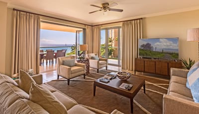 Cozy, open living space with tropical tones, plush seating, and direct access to a breezy lanai.
