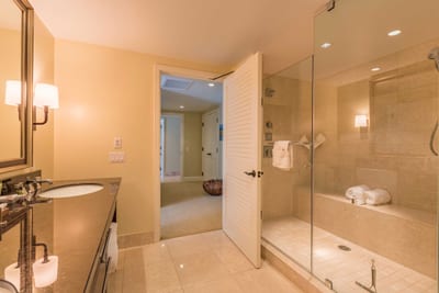 Glass shower and rich tile give this bathroom a touch of luxury