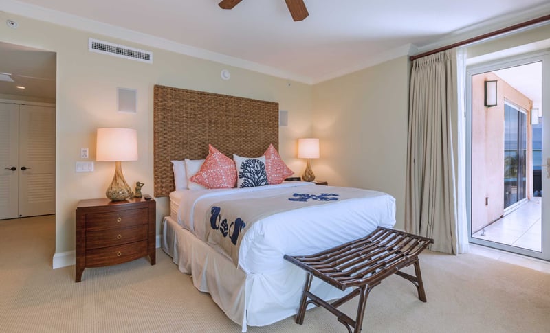 Comfortable master suite with coastal decor and direct access to lanai for peaceful morning views.