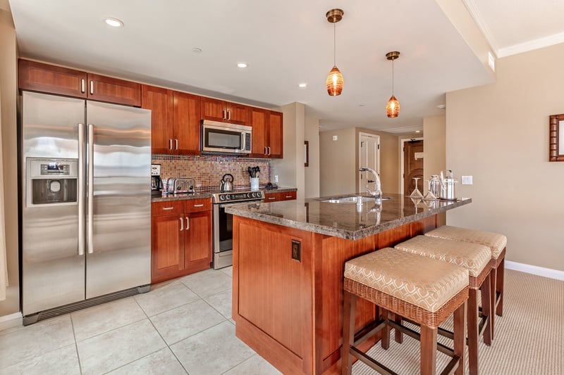 Stylish kitchen with island seating, granite counters, and pendant lighting. HKK-513