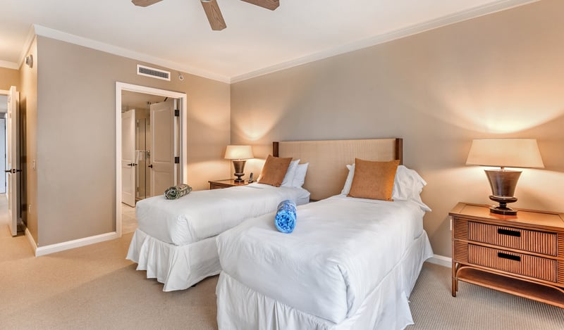 Comfortable twin bedroom with warm lighting and ensuite bath access. HKK-513