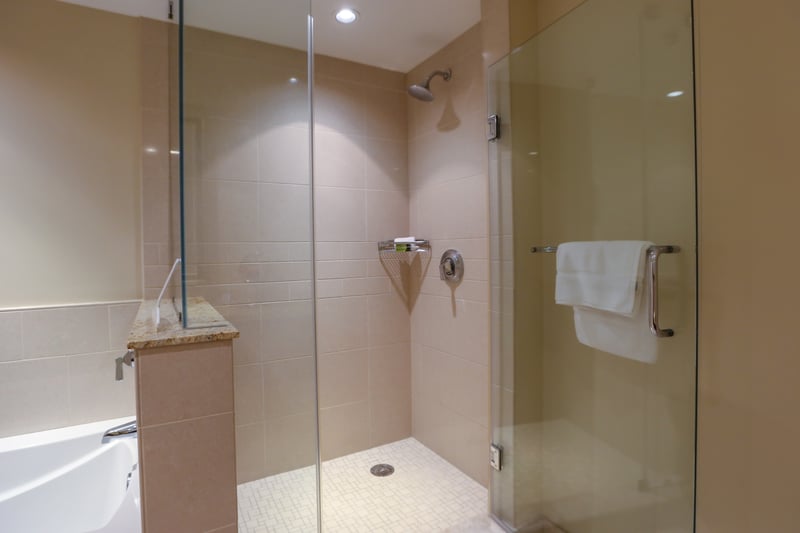 Sleek walk-in glass shower with tile detail and modern fixtures. HKK-513