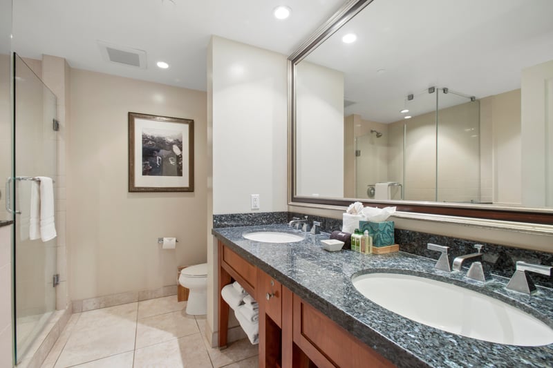Spacious luxury bathroom with double sinks, glass shower, and serene finishes.