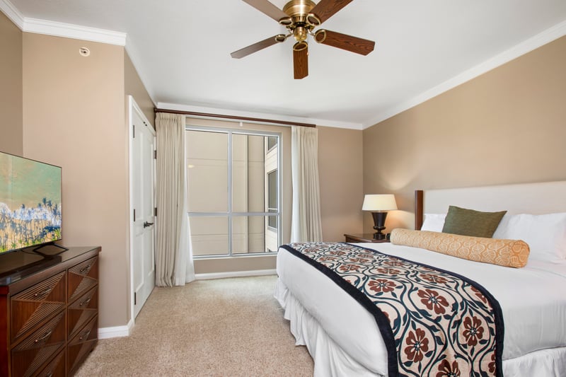 Bright island bedroom with ceiling fan, floral comfort, and serene ambiance.