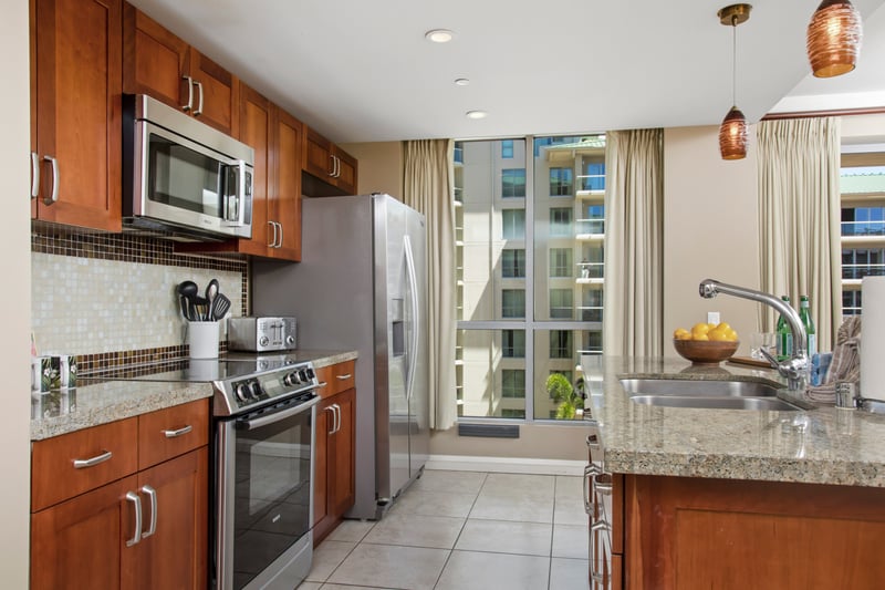 Sunlit modern kitchen with granite counters, stainless appliances, and charm.