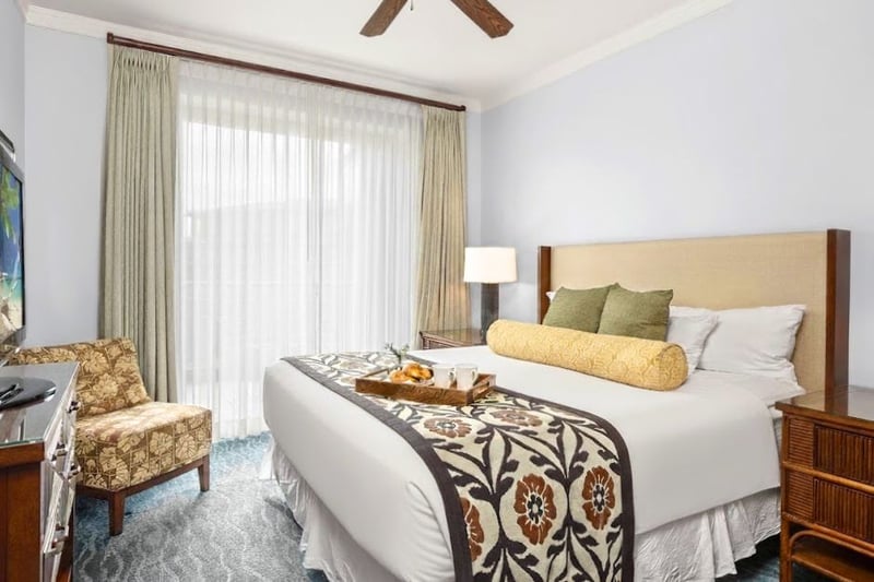 Primary bedroom at Honua Kai Konea 706 — king bed with in-room breakfast service and flat-screen TV