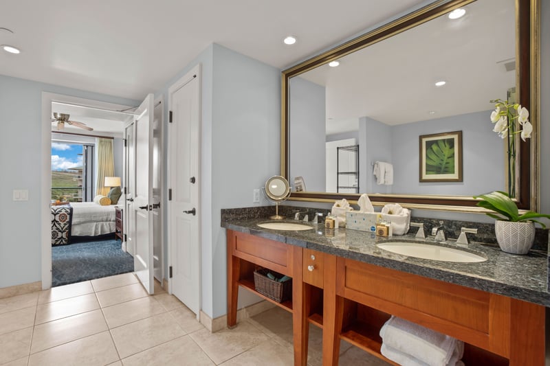 Modern bathroom with spa-like vanity and bedroom view beyond.