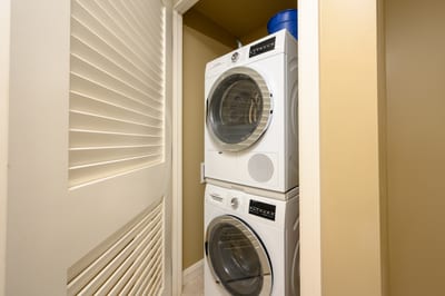 Compact laundry closet with stacked Bosch washer and dryer units. HKK-812
