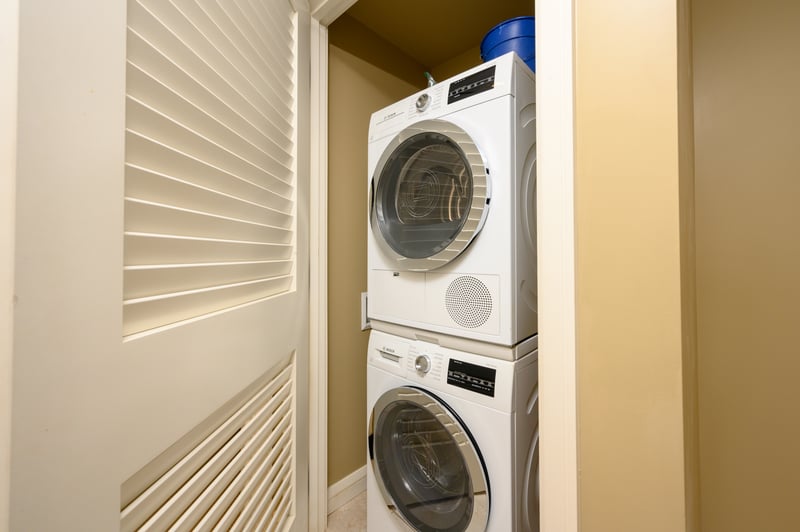 Compact laundry closet with stacked Bosch washer and dryer units.