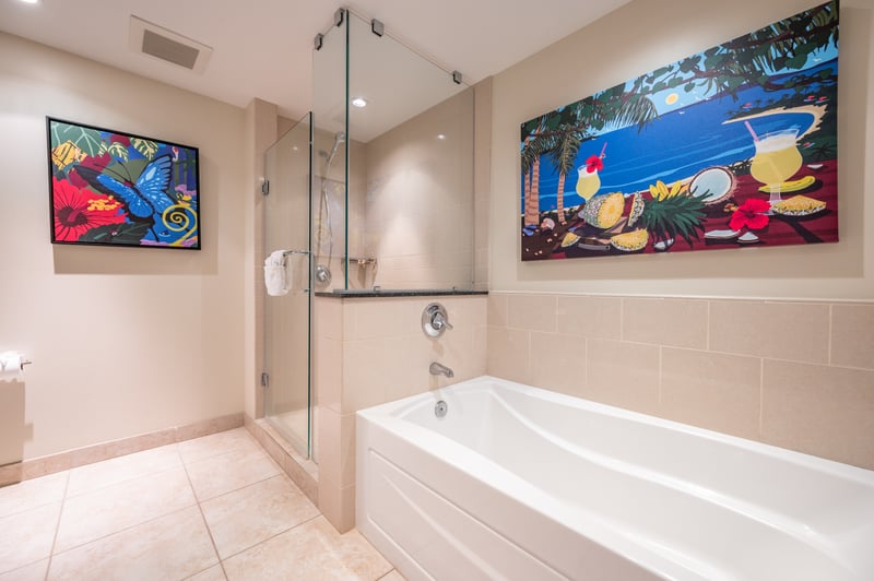 Vibrant tropical bathroom with glass shower and relaxing soaking tub