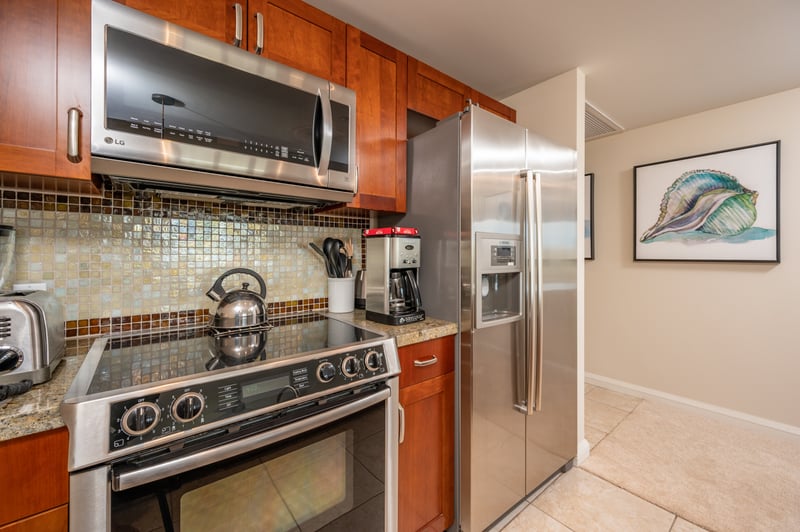 Fully equipped modern kitchen with stainless appliances and coastal charm.