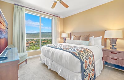 Bright bedroom escape with mountain views, coastal charm, and serene luxury.