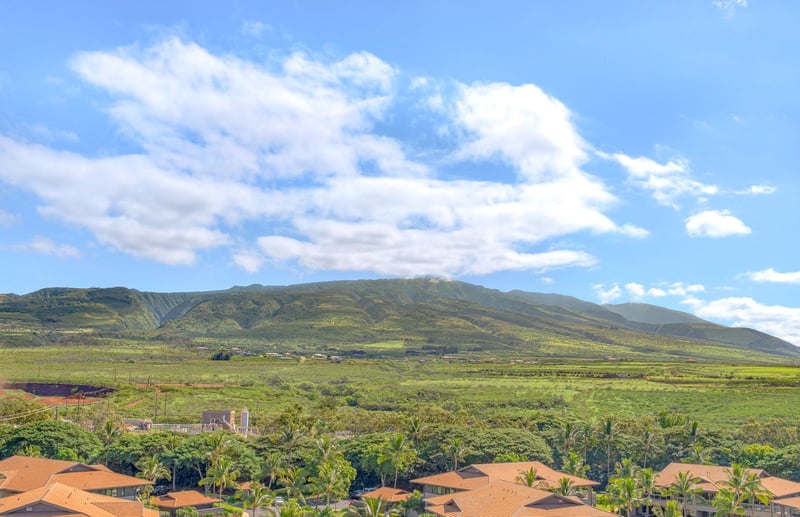 Lush green valleys, sun-kissed rooftops, majestic mountains meet sky.