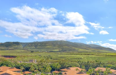 Lush green valleys, sun-kissed rooftops, majestic mountains meet sky.