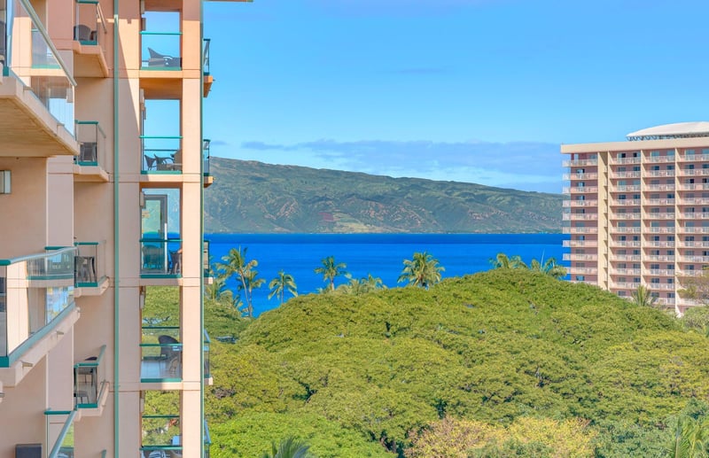 Balcony views framed by lush canopy, ocean bliss, and island cliffs. HKK-820