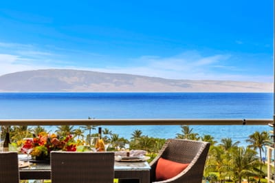 Spacious balcony with dining and lounge seating framed by sweeping ocean and garden views. HKK-825