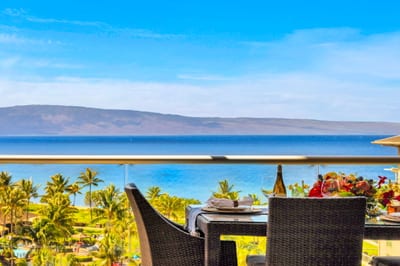 Elevated ocean view stretches over lush palms and rooftops to the sparkling blue beyond. HKK-825