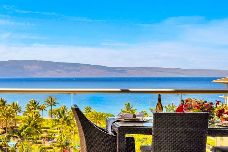 Elevated ocean view stretches over lush palms and rooftops to the sparkling blue beyond. HKK-825
