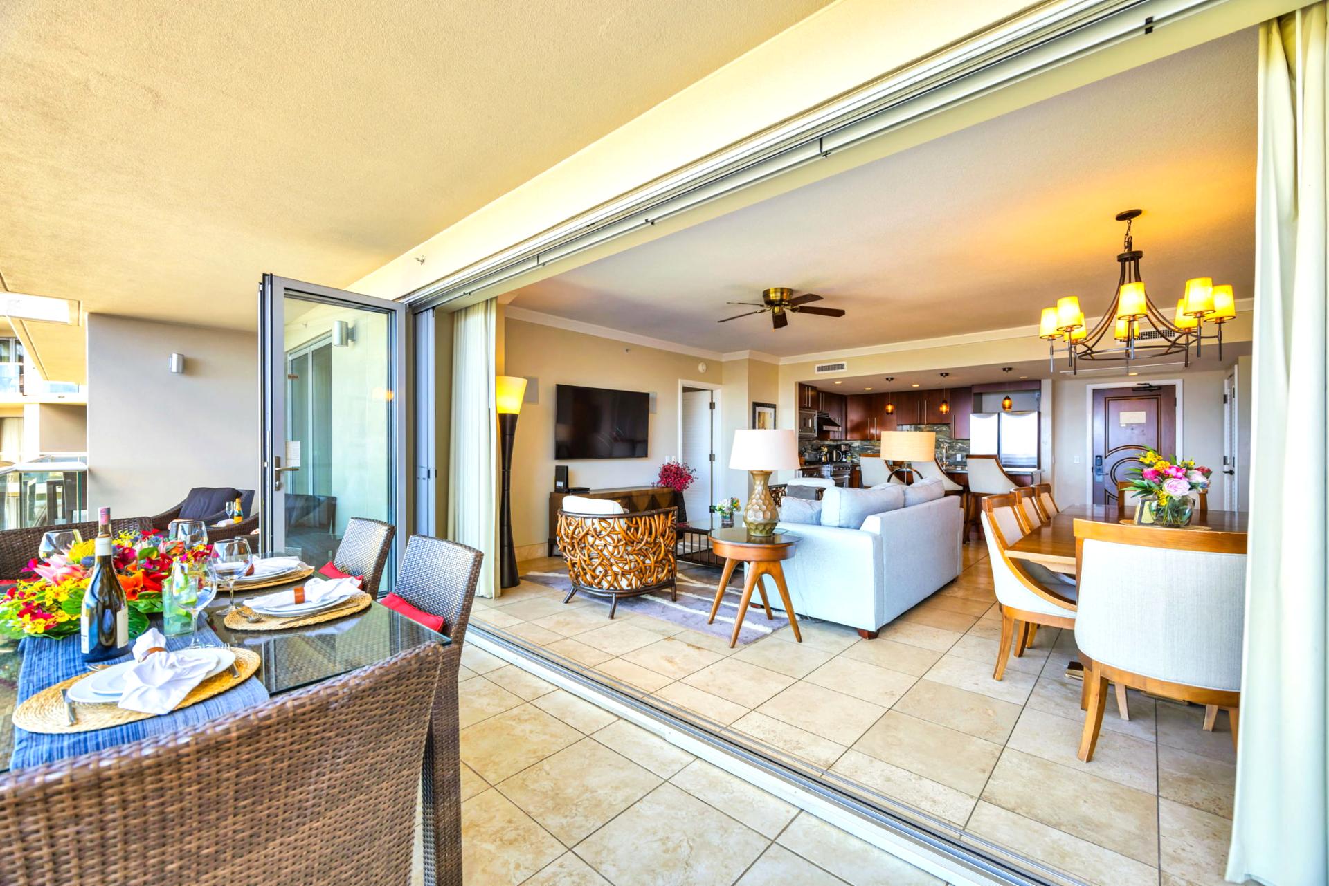 Open living layout with direct lanai access and tropical views through floor-to-ceiling glass.