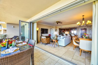 Open living layout with direct lanai access and tropical views through floor-to-ceiling glass. HKK-825