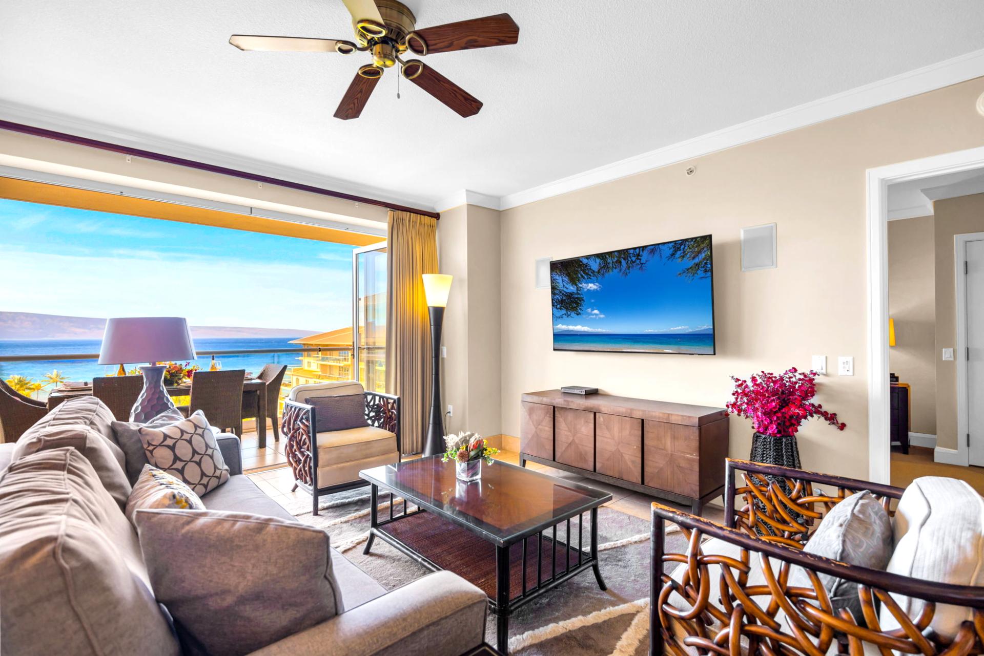 Comfortable living area with sectional sofa, Smart TV, and island views through wide sliding doors.