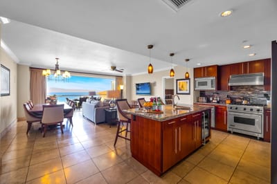 Well-appointed kitchen with wraparound counters, breakfast bar, and wood cabinetry. HKK-825