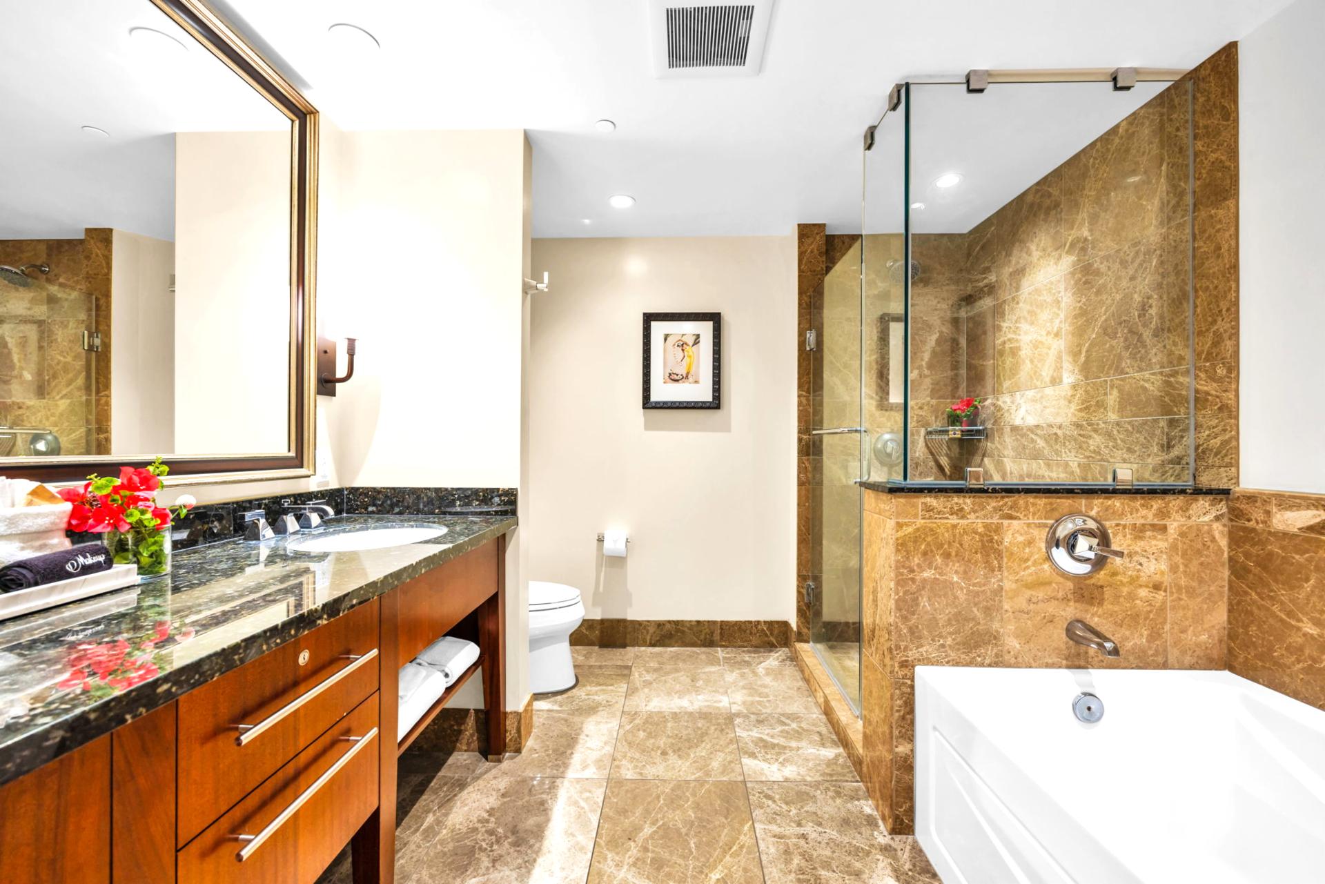 Well-lit guest bathroom with granite vanity and tiled walls.