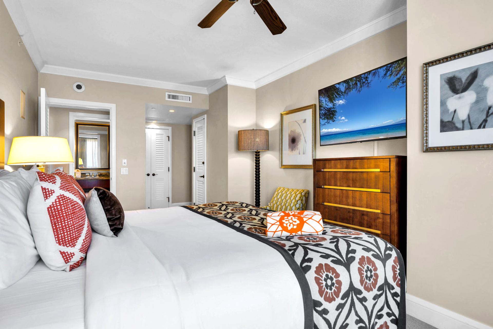 King bed and accent chair in a calm, coastal-inspired guest bedroom.