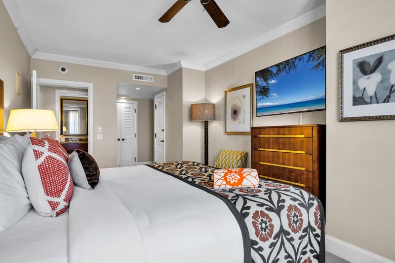 King bed and accent chair in a calm, coastal-inspired guest bedroom.